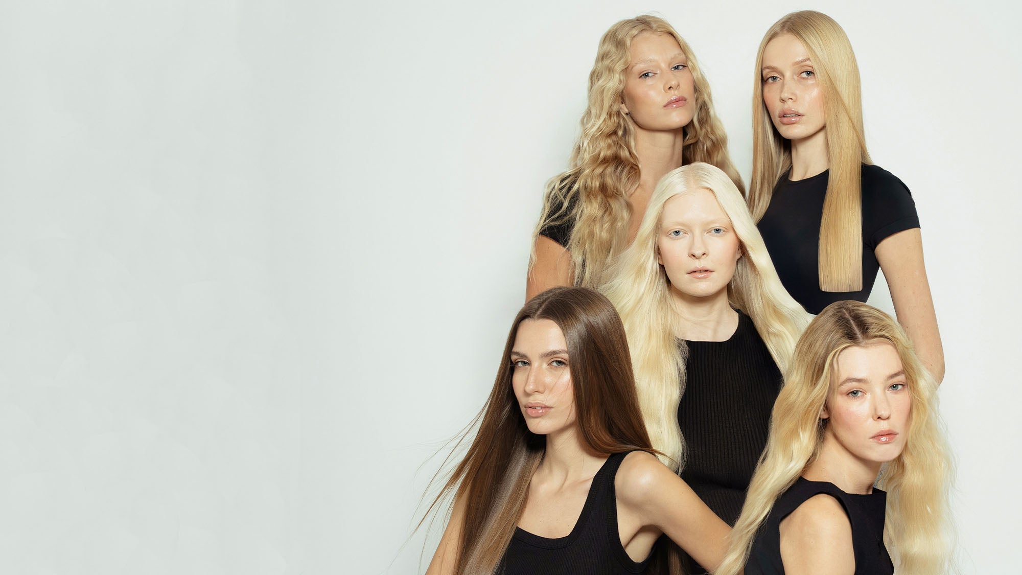 Five women with different hairstyles wearing black tops against a white background modelling for 1010 Extensions