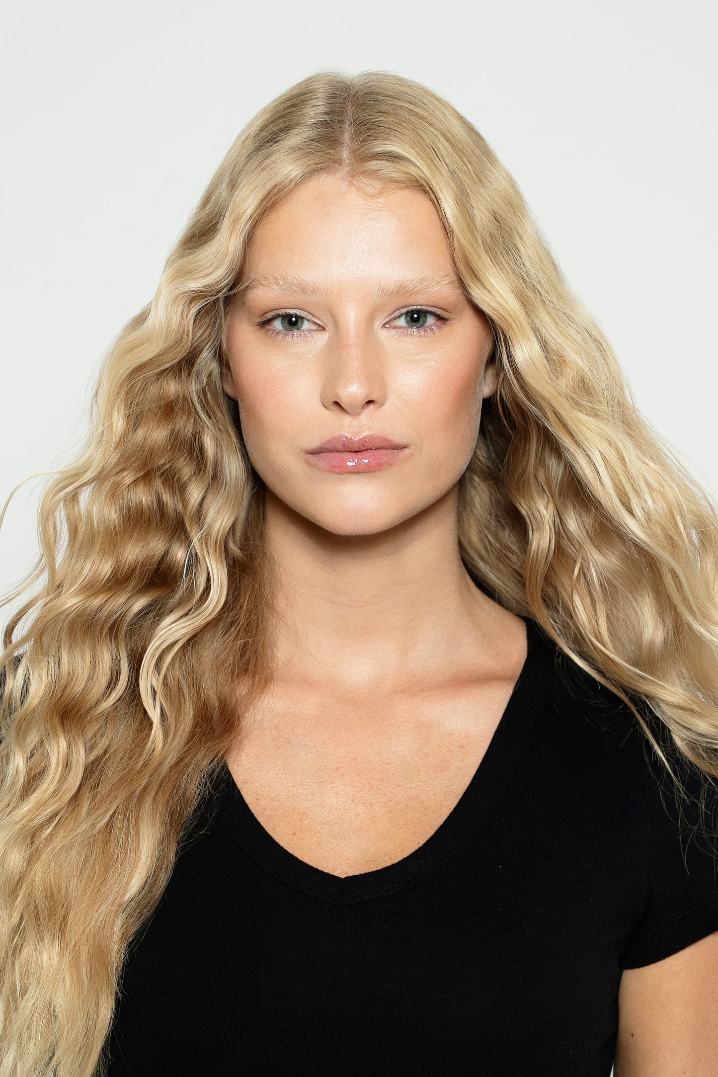 Model wearing 100% human hair clip-ins in warm blonde, styled in beachy waves