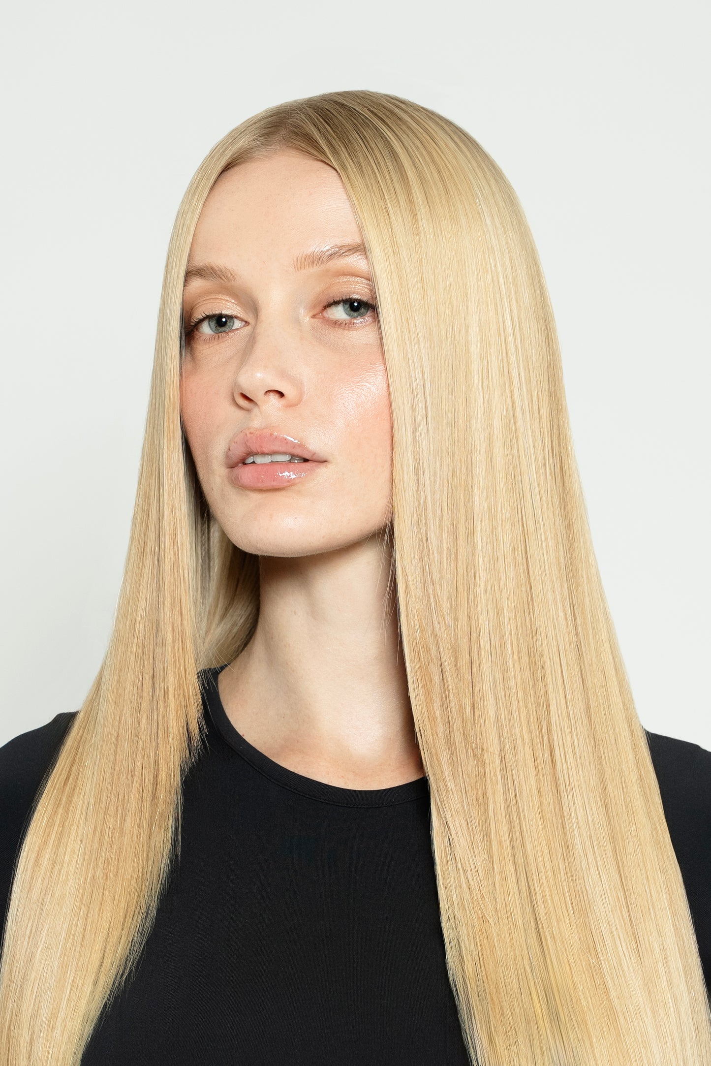 Model styled with neutral blonde clip-ins for a soft, natural-looking finish