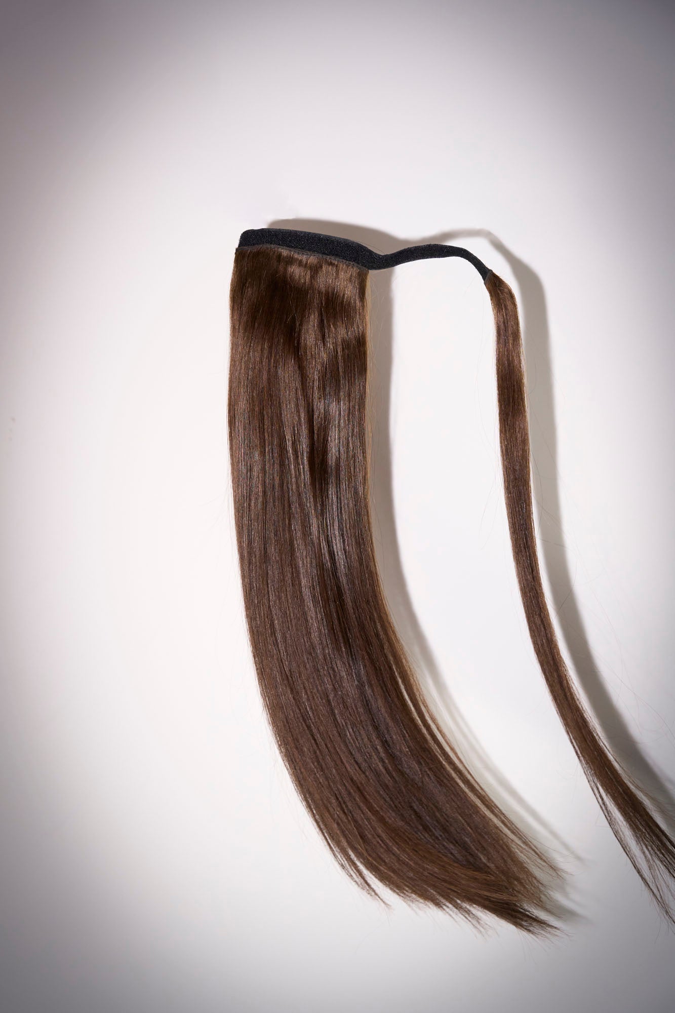 1010 Extensions ponytail in dark brown adding shine and volume to model’s hairstyle