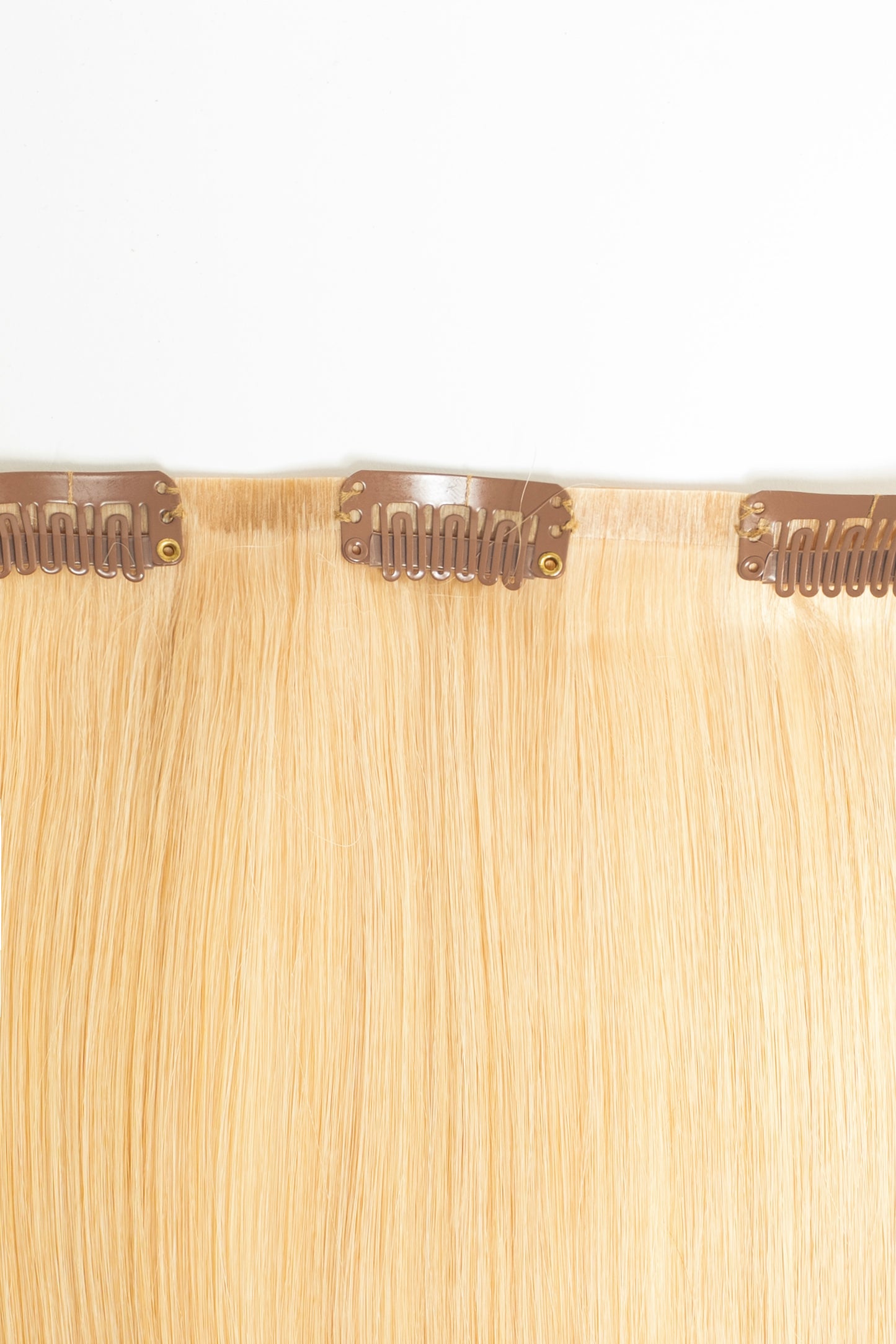 7-piece warm blonde clip-in set with soft texture and brilliant shine by 1010 Extensions