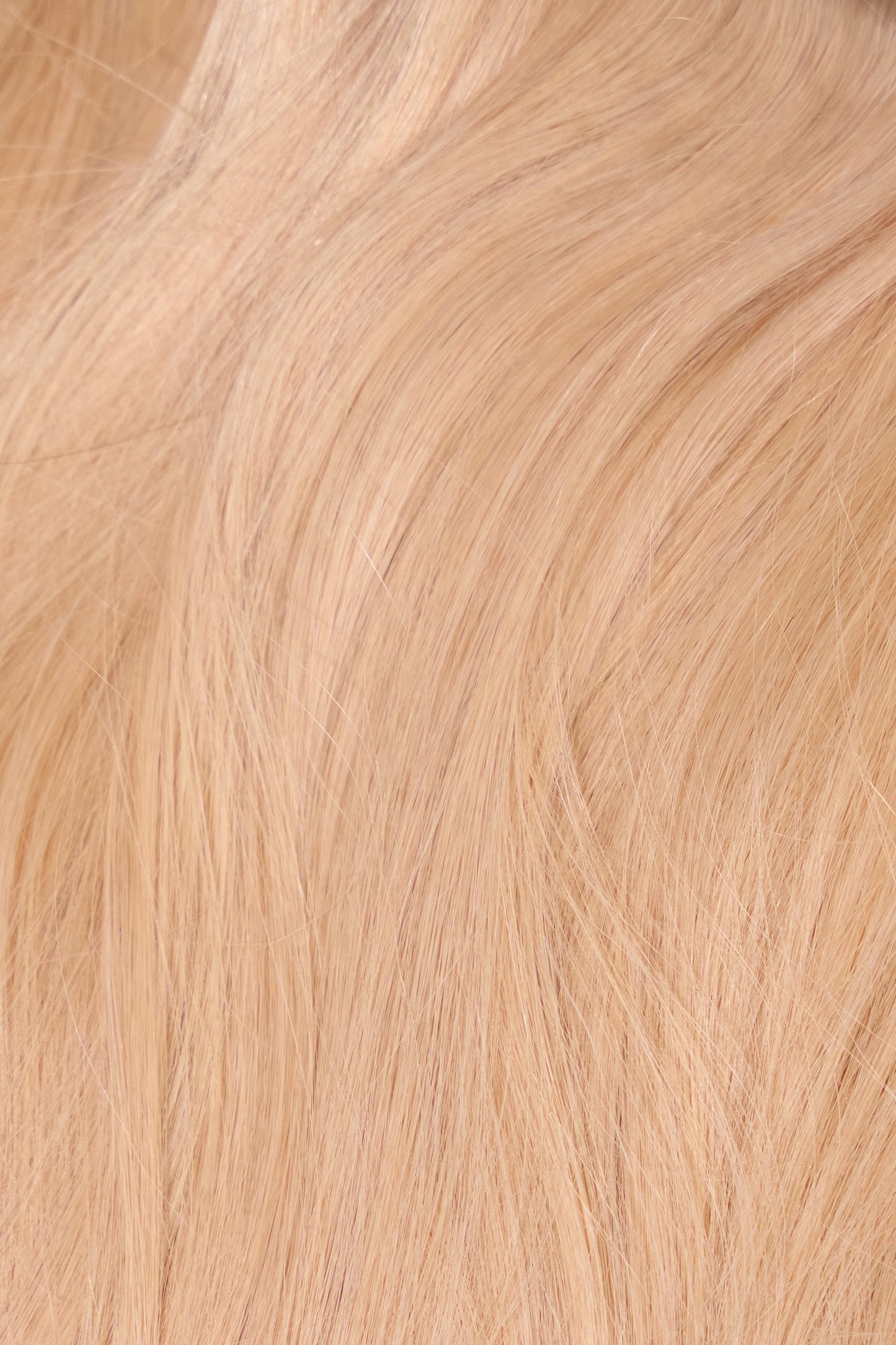 Close-up of thick, shiny bright blonde machine weft bundle designed for volume and length