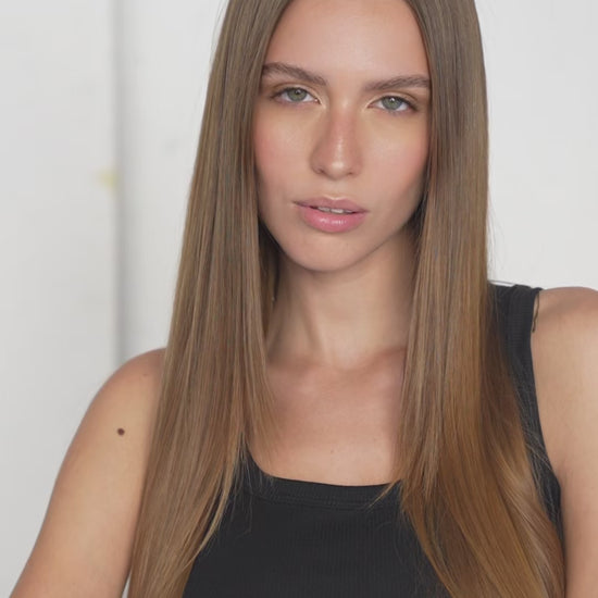 Close-up of silky light brown clip-in hair extensions with seamless attachment